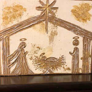 Textured gold painted Nativity on wood.